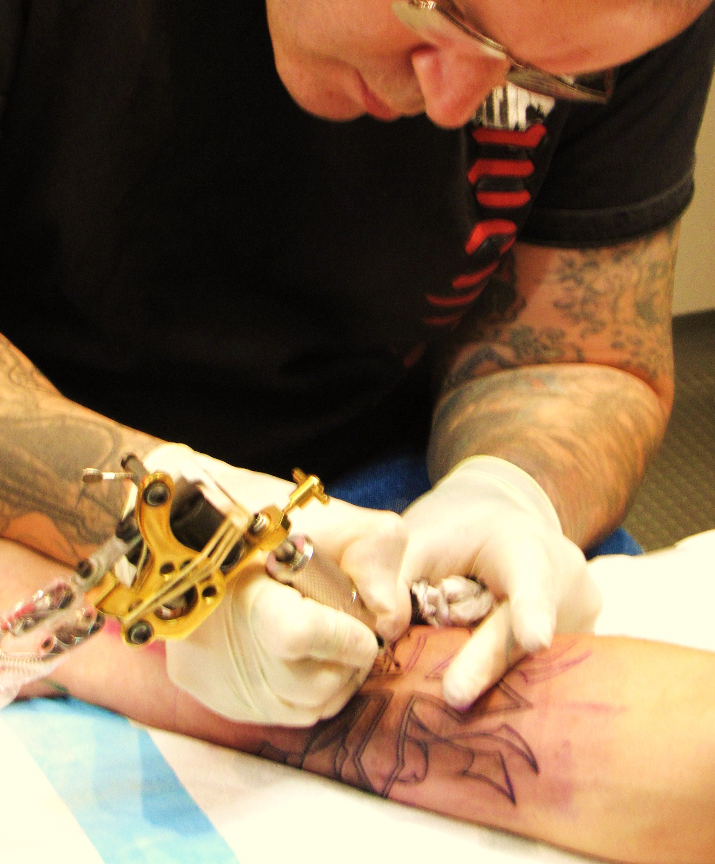A tattoo artist at work in